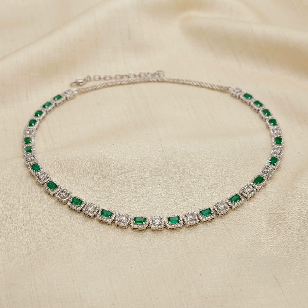 Silver-toned necklace featuring a sparkling row of emerald-cut green stones accented with brilliant American diamond