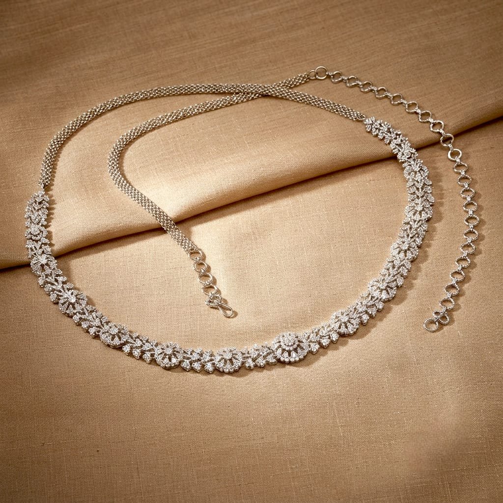 Silver-toned, rhinestone-studded waist belt (vaddanam or kamarbandh) featuring a floral and leaf pattern.