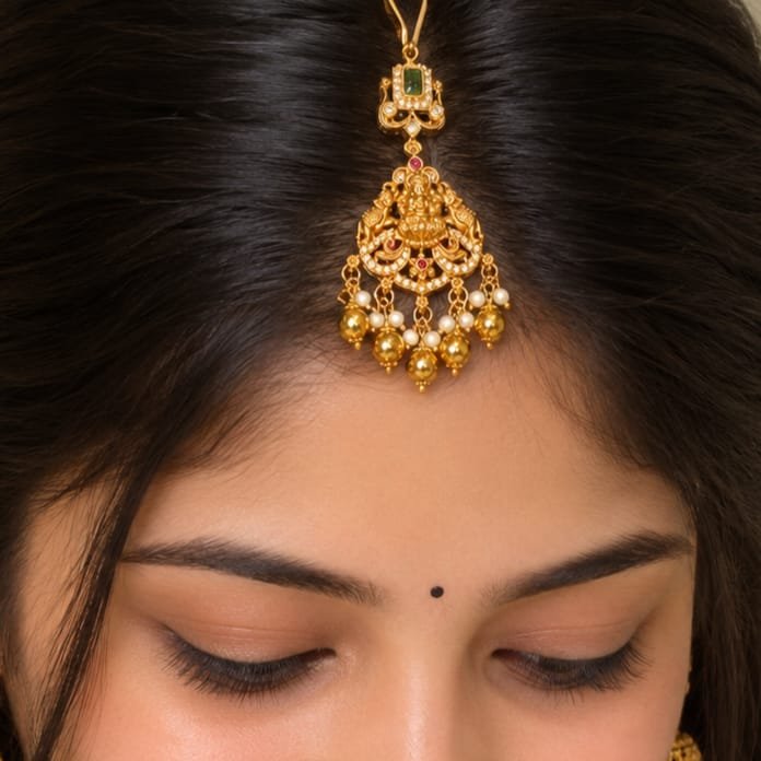Temple maang tikka featuring an intricate Goddess Lakshmi motif and delicate pearl drops